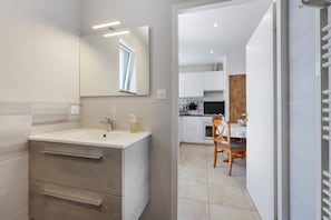 A modern bathroom with a large mirror, a sink, and a vanity with drawers. - The Cozy Nest, 2 to 4 Guests, Heated Pool, in Vendée! (Commequiers)