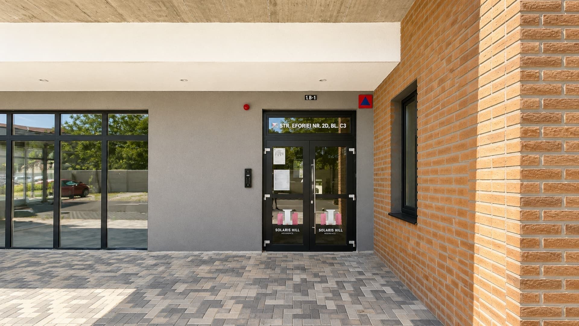 Een gebouw ingang met een glazen deur waarop 'Solaris Hill Residence' staat.