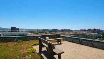 Un banc de pierre donnant sur un paysage urbain, avec des bâtiments et de la verdure.