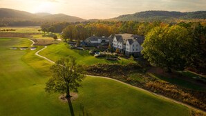 A golf course with a clubhouse and a large building with multiple windows. - Pursell Farms (Sylacauga)