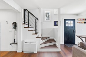 Eine moderne Treppe mit schwarzer Handläufe und Holzsitzen, die zu einer dunklen Tür führt.