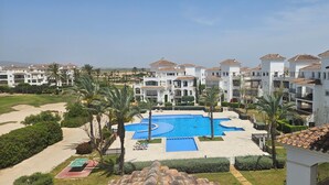 A resort with multiple white buildings, a central swimming pool, and palm trees. - Exclusive Silent & Sunny Top Floor Apartement, 2 Pools & Golfview (Roldan)