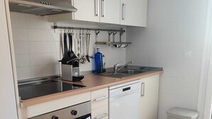 A modern kitchen with white cabinetry, a built-in oven, a dishwasher, and a stainless steel sink. - Exclusive Silent & Sunny Top Floor Apartement, 2 Pools & Golfview (Roldan)