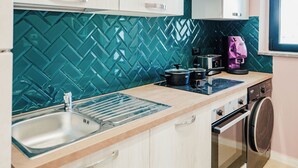 Una cocina con lavamanos, estufa y cafetera.