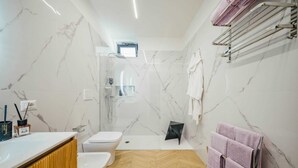 Un baño moderno con ducha, inodoro, bidé y suelo de madera.