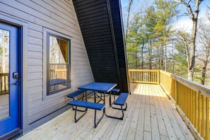 A deck with a table and benches, a blue door, and a view of trees. - Chimney Rock Chalet w Mountain Views Near Main St (Wytheville)