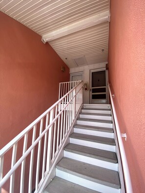 A staircase with white railings leading to a door. - Waterfront 1 BR Condo Private Beach, Pool & Sunset Views 30 DAY MIN (St. Petersburg)