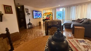 A living room with a wooden floor, a television, a piano, and a sofa. - Beautiful Condesa Private Apartment (Ciudad de México)