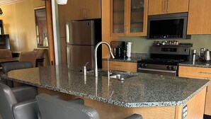 A modern kitchen with granite countertops, stainless steel appliances, and wooden cabinets. - Contemporary 3-Bedroom Rowhouse on Capitol Hill (Washington)
