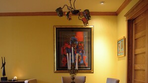 A dining room with a wooden table, four chairs, a chandelier, a framed painting, and a patterned rug. - Contemporary 3-Bedroom Rowhouse on Capitol Hill (Washington)