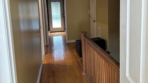 A hallway with wooden flooring, white doors, and a ceiling fan. - Contemporary 3-Bedroom Rowhouse on Capitol Hill (Washington)