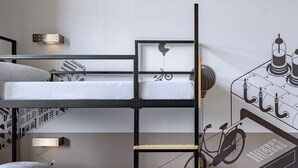 Camera con letto a castello, una scala, un quadro raffigurante una bicicletta e un portalampada a parete.