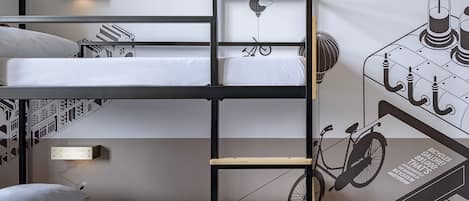 A bunk bed room with a ladder, a bicycle wall art, and a wall-mounted light fixture.