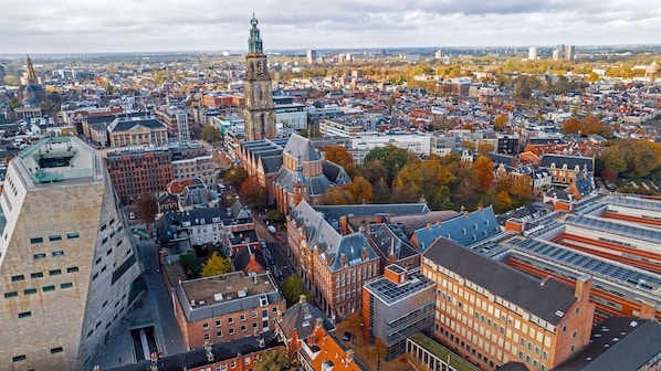 A cityscape with historic buildings, a prominent tower, and a mix of modern and traditional architecture. - Stayokay Hostel Groningen (Groningen)