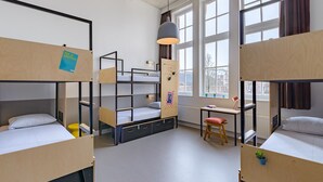 Una camera del dormitorio con letti a castello, una scrivania, una sedia e una lampada a sospensione.