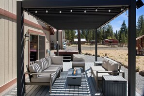An outdoor patio with a sofa set, a coffee table, and a pergola with lights. - South of Sunriver - Near Mt Bachelor - Hot Tub (Bend)