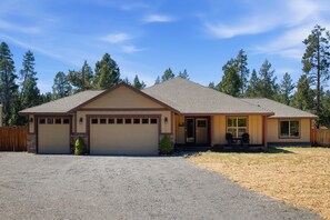 A single-story house with a garage, a covered porch, and a driveway. - South of Sunriver - Near Mt Bachelor - Hot Tub (Bend)