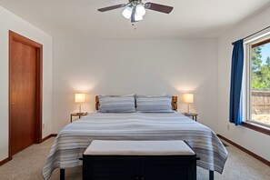 A bedroom with a bed, bedside lamps, a ceiling fan, and a window with curtains. - South of Sunriver - Near Mt Bachelor - Hot Tub (Bend)