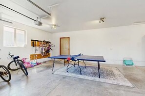 A spacious room with a ping pong table, bicycles, and a ceiling fan. - South of Sunriver - Near Mt Bachelor - Hot Tub (Bend)