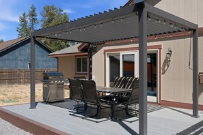 A covered patio with a grill, outdoor table, and chairs. - South of Sunriver - Near Mt Bachelor - Hot Tub (Bend)
