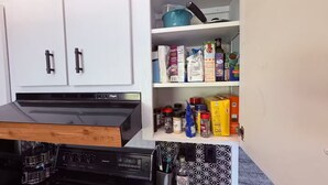 Eine Küche mit Herd, Backofen und Schränken.