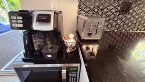 Eine Küche mit Kaffeemaschine, Toaster und Mikrowelle.