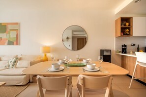A modern dining area with a round table, chairs, and a mirror on the wall. - Born | Modern 2BR with Pools and Gym (Bavaro)