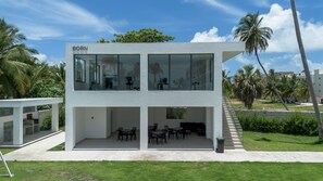 A modern two-story building with large windows and a flat roof. - Born | Modern 2BR with Pools and Gym (Bavaro)