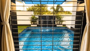 Una piscina amb vistes a l'exterior, envoltada per una tanca.