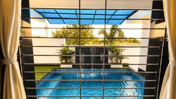 Piscina com vista para o exterior, cercada por uma grade.