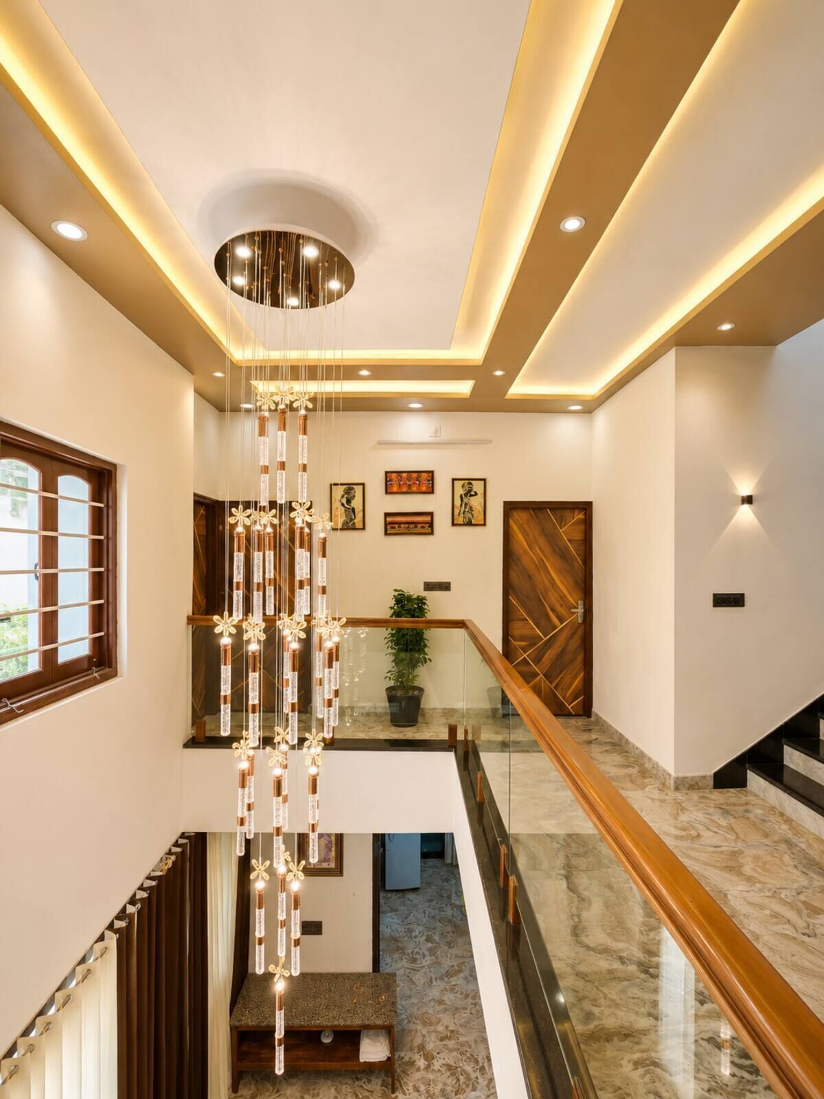 A modern interior with a staircase, a hanging light fixture, and a wooden door.