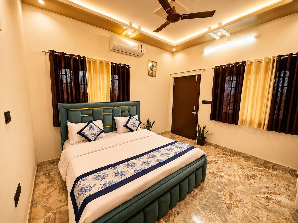 A bedroom with a bed, curtains, a ceiling fan, and an air conditioning unit.