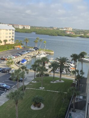 A marina with boats docked, a parking lot with cars, and a building with a flat roof in the background. - HAPPY PLACE! Charming condo in marvelous Siesta Key perfect for your getaway (Siesta Key)