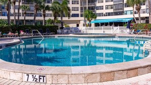 A swimming pool with lounge chairs and a no diving sign, surrounded by palm trees and a multi-story building. - HAPPY PLACE! Charming condo in marvelous Siesta Key perfect for your getaway (Siesta Key)