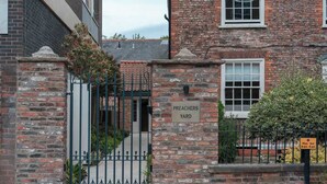 Un edificio in mattoni con un cancello su cui si legge 'PREACHERS YARD' e un'insegna con gli orari di apertura.