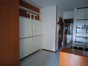 A kitchen with white cabinets, a wooden countertop, and a white ladder.