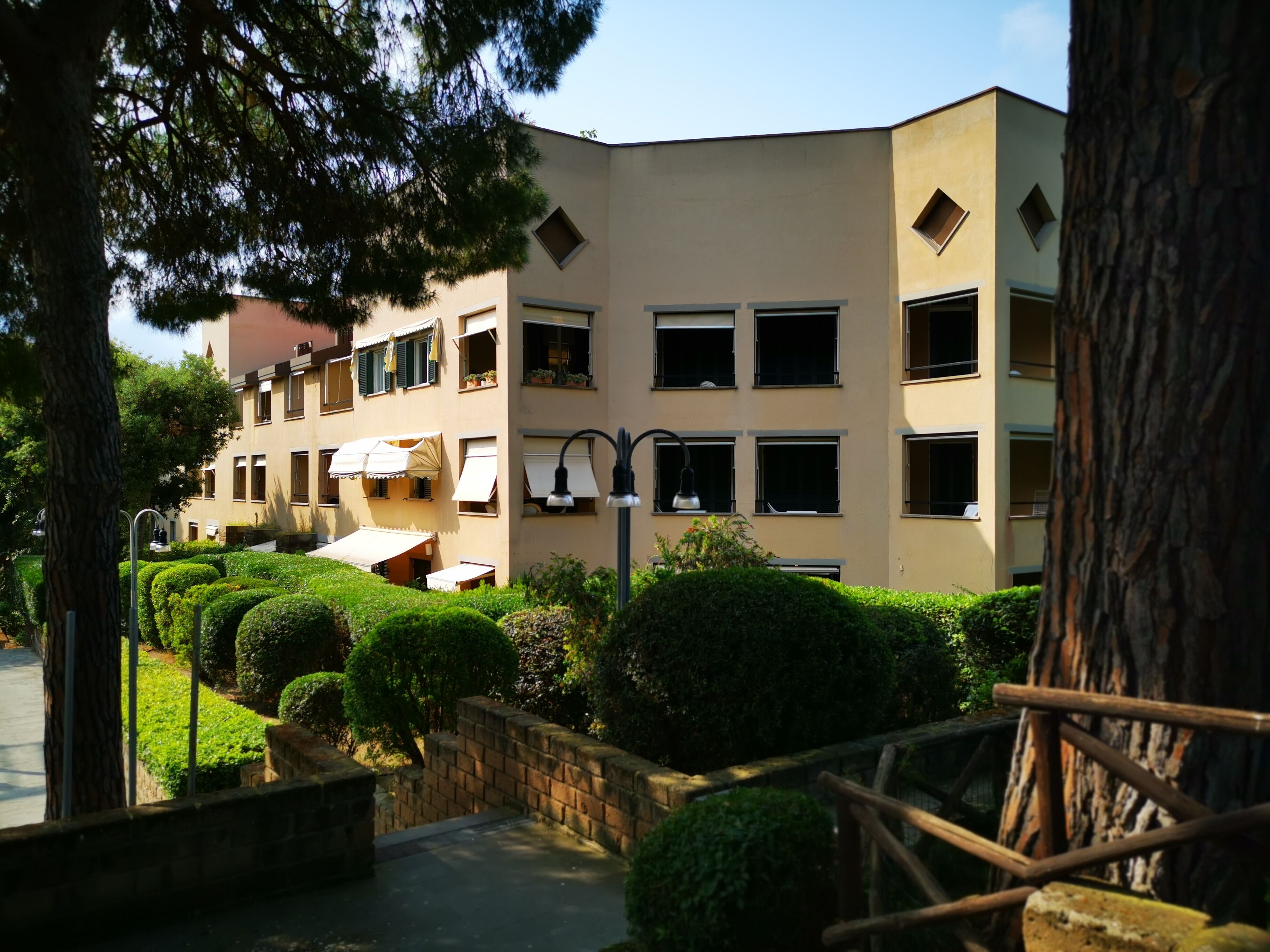 Un immeuble à plusieurs étages, doté d’une façade symétrique, de nombreuses fenêtres et d’une entrée centrale.