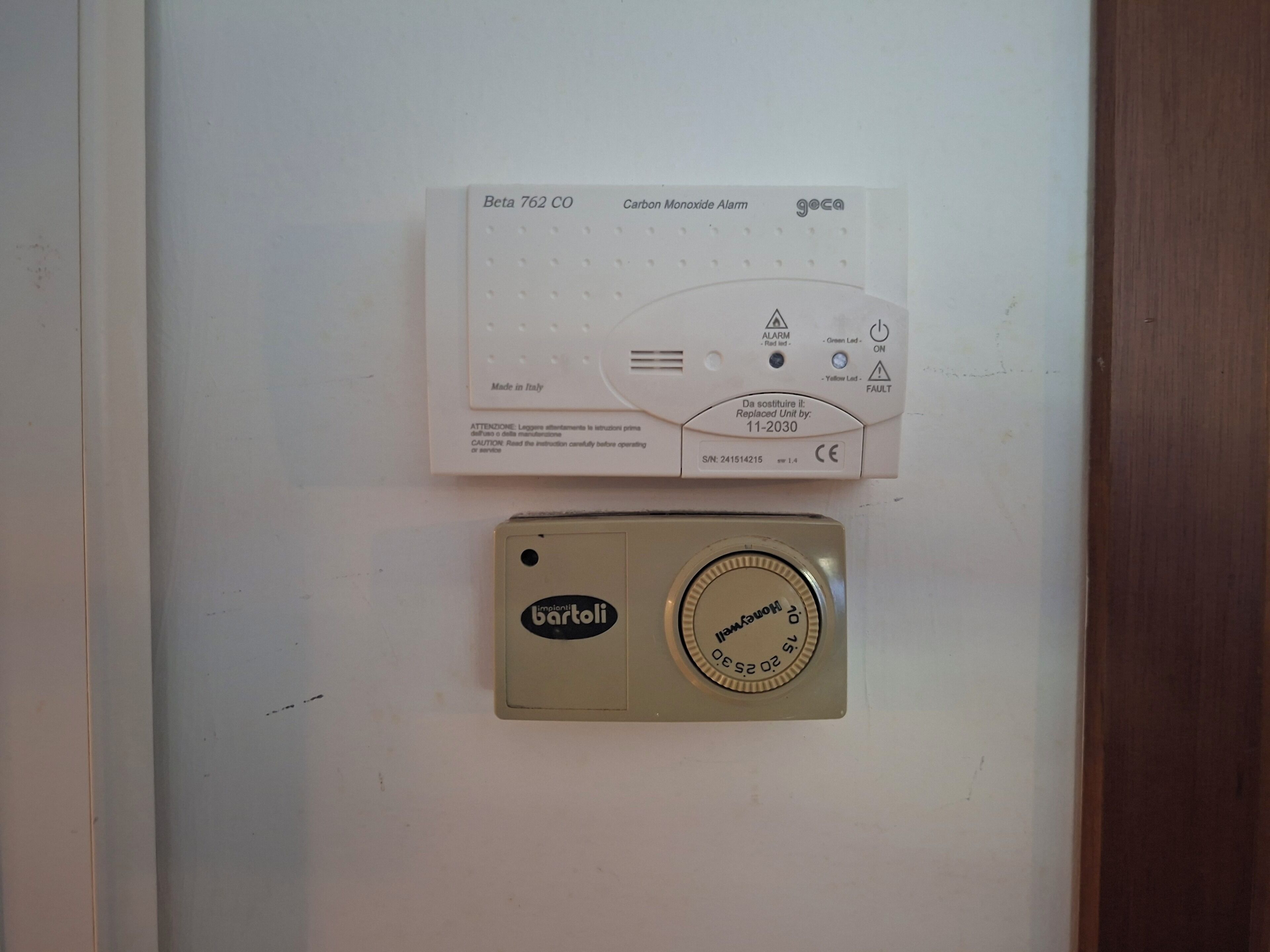 Un détecteur de monoxyde de carbone et un thermostat fixés au mur.