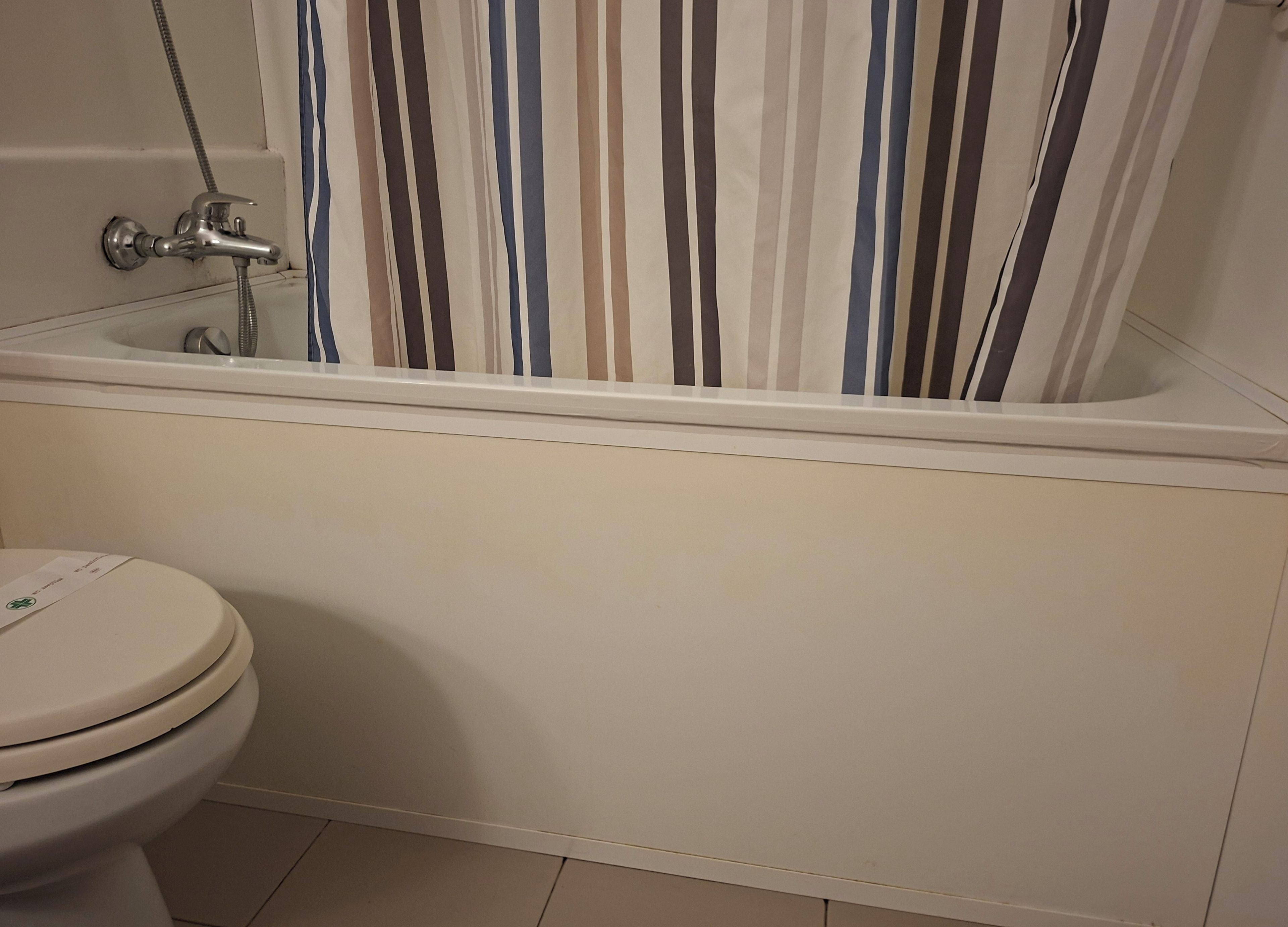 Ein Badezimmer mit Toilette, Badewanne und Dusche.