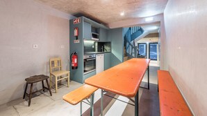 A compact kitchen with a microwave, oven, and a fire extinguisher on the wall. - Casa do Ofício - Boilermaker 1 by Hosty (Porto)