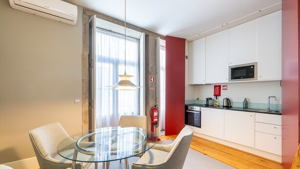 A modern kitchen with white cabinets, a microwave, and a coffee maker. - Casa do Ofício - Bookseller 3 by Hosty (Porto)