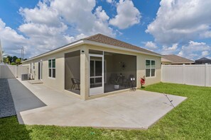 A single-story house with a covered patio, a sliding glass door, and a fenced backyard. - Welcome to the Elegant 3/2 Courtyard Villa in the Village of Hawkins (The Villages)