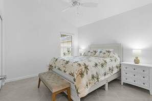 A bedroom with a bed, bench, nightstand, and a ceiling fan. - Welcome to the Elegant 3/2 Courtyard Villa in the Village of Hawkins (The Villages)