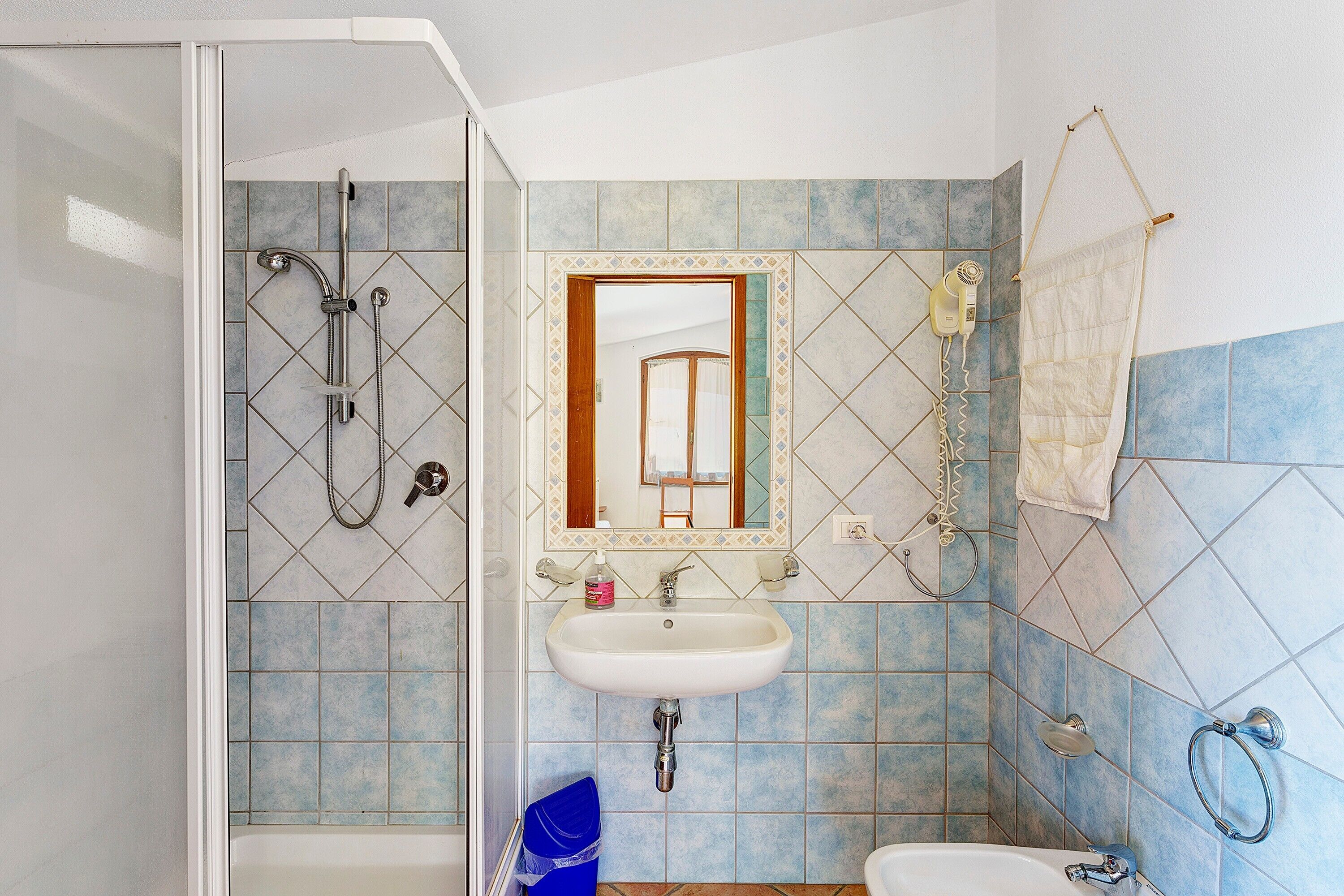 Een badkamer met een douche, wastafel en toilet.