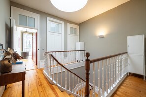 Eine Treppe mit weißen Balustraden und einem hölzernen Geländer, die zu einer oberen Etage führt.