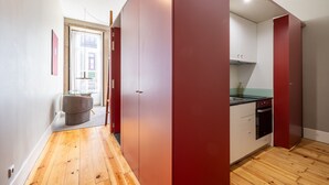 A modern kitchen with a built-in oven and a small dining area with a glass table. - Casa do Ofício - Bookseller 4 by Hosty (Porto)