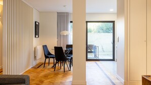 A modern interior with a dining area, a large window, and a view of the outdoors. - Casa do Ofício - Galerista by Hosty (Porto)