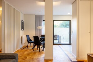A modern interior with a dining area, a large window, and a view of the outdoors. - Casa do Ofício - Galerista by Hosty (Porto)