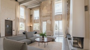 Un salón amplio con un sofá modular grande, una mesa de centro redonda y una chimenea.