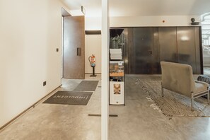 Ein modernes Interieur mit einer Tür, einem Feuerlöscher, einem Stuhl und einem Teppich.
